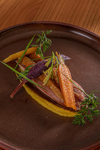 Plat : Filet de canard rôti sur coffre, purée de carotte jaune, cuisse confite en bao bun, jus à l’orange.